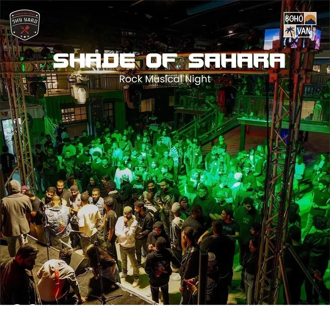 Shade of Sahara rock music night, a green-lit crowd filling the yard